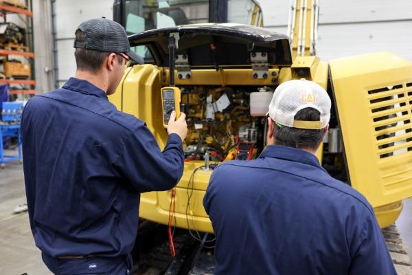 two diesel students working on equipment in lab