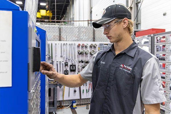 FVTC student pressing buttons on control board in diesel shop