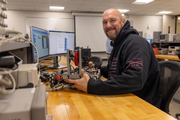 students work in an electronics lab with instructor