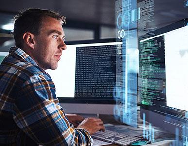 man working on software development coding using two monitors